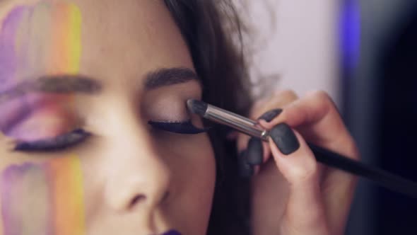 Closeup View of Makeup Artist Makes Models Eye Makeup with False Eyelashes alt
