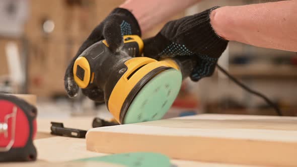 Man Using Orbital Wood Sander in Workshop alt