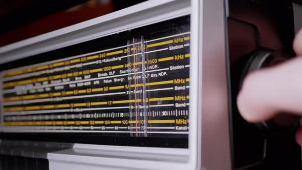 Female Fingers Adjusting the Frequency on an Old Vintage Analog Receiver alt