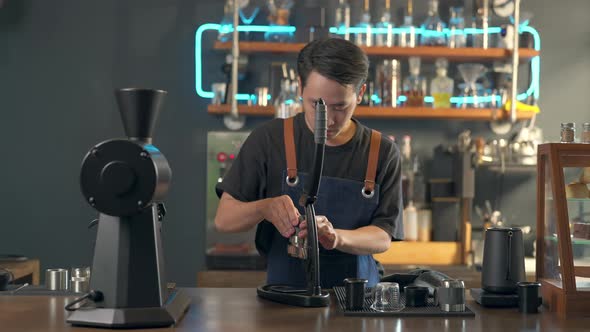 4K Asian man barista making hot espresso shot from flair espresso coffee maker alt