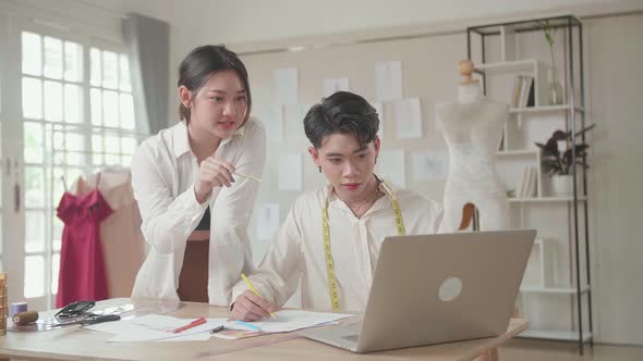 Two Fashion Designers Working With Laptop And Sketching At Fashion Design Studio alt