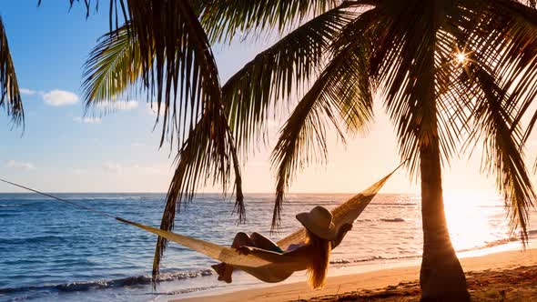 Woman in hammock on beach alt