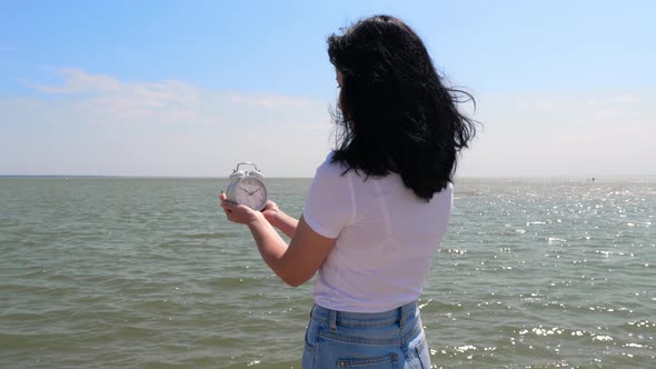 The Girl Holds a Watch in Her Hands and Looks at the Time alt