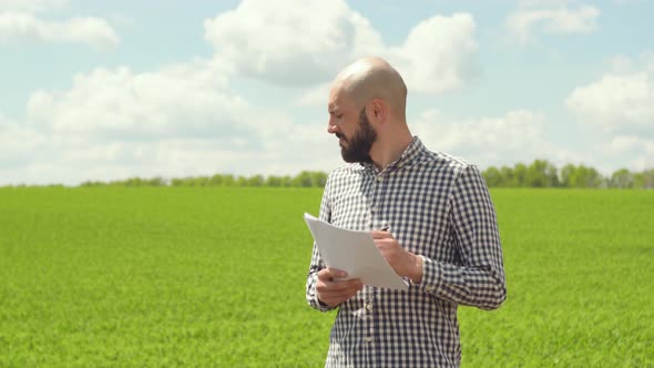 Agronomist or Farmer Examines Soybean Growth alt