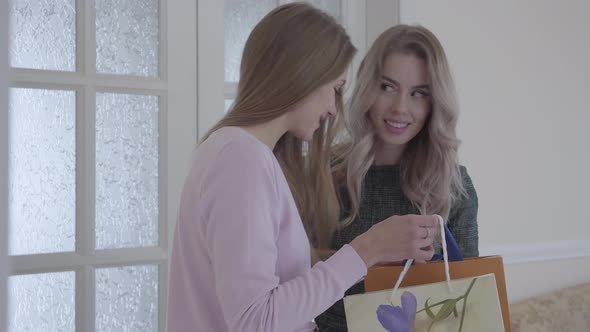Young Woman Brings Present To Her Friend alt