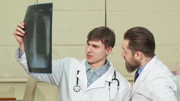 Two Male Doctors Examining Lungs X-ray of a Patient alt