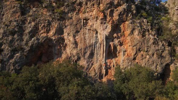 Aerial Slow Motion Footage From Drone of Man Rock Climber Hanging on Rope and Rappelling Through the alt