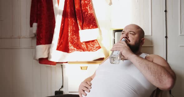 Concept of Bad Santa Claus Man Actor Drinks Alcohol in Dressing Room While Wait alt