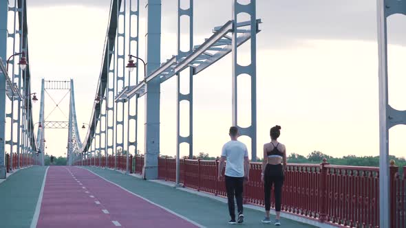 Sports Couple Walks on the Bridge
