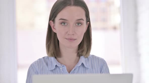 Portrait of Young Woman Doing Thumbs Up in Office alt