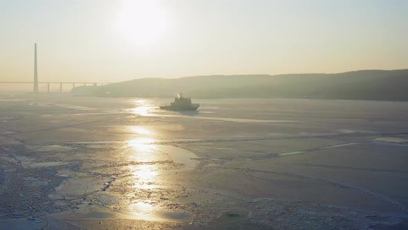 Drone View of the Silhouette of an Icebreaker Anchored Among the Ice at Dawn alt