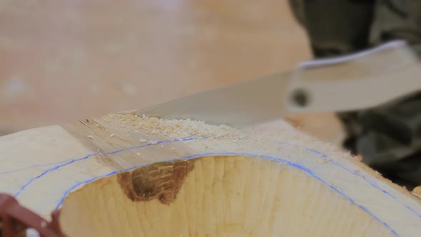 Man Carpenter Cutting Wood Piece with Saw  Close Up