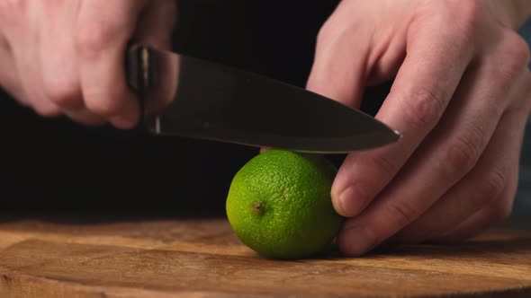 Sliced in half fresh lime with knife on wooden chopping board. Close up. 4k