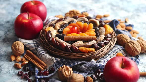 Composition of Dried Fruits and Nuts in Small Wicker Bowl Placed on Stone Table alt