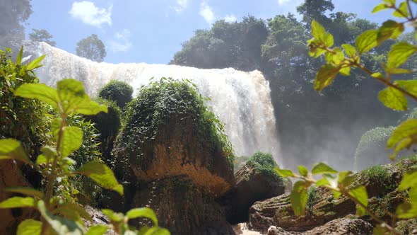 Mesmerizing Waterfall with Natural Light, Blue Summer Sky and Green Leaves alt