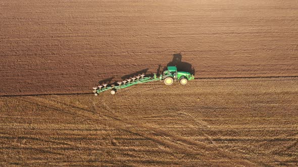 Agricultural Works In Rural Field Tractor Ploughing Ground Land With Plow alt