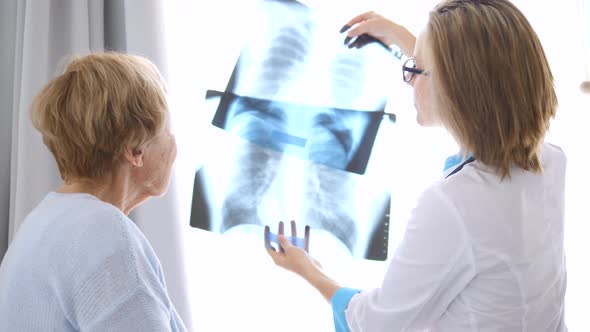 Healthcare, Medical Concept. Doctor Showing Xray To An Elderly Patient. alt