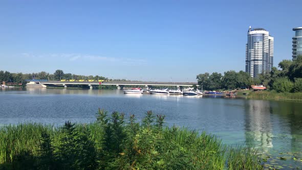 Yellow subway cars passes over the bridge. Nature within the metropolis. Kiev, Ukraine. alt