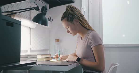 Teenage Student Girl Do Written Exercises in Workbook Preparing To Exams or Tests at Her Work Place alt