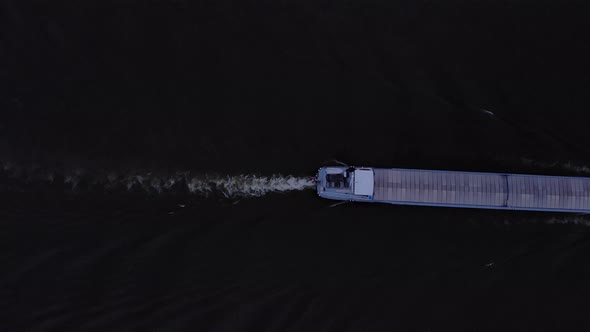 Wake Of A River Cargo Ship Passing Barge Navigation Transporting Goods At Sunset In River Noord, Net alt