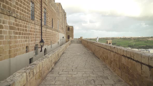 Long Stone Path on Cittadella Fortress Defensive Wall on Bright Day with City in Background
