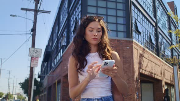 Young Woman Use Smartphone Standing on Crossroad alt
