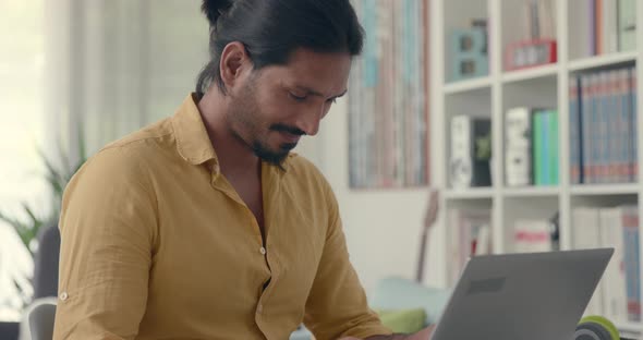 Happy man chatting with his laptop at home