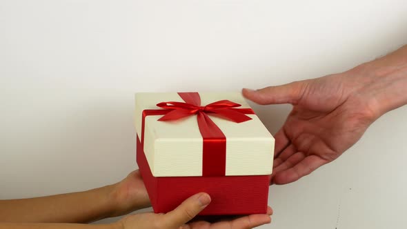 A man gives a woman a Merry Christmas present. New Year and Christmas gifts in bright boxes