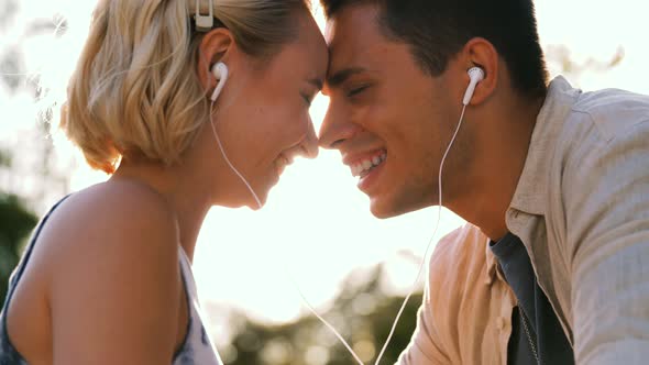 Happy Couple with Earphones Listening to Music