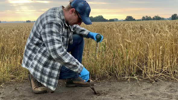 Farmer Measuring Soil pH Value Moisture Temperature Using Soil Tester alt