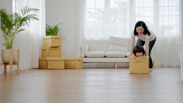 asian family playing with a box. Together having fun inside the house