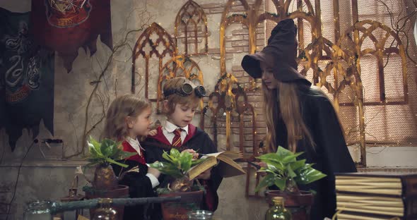 Older Student is Teaching Little Children Some Magic with a Book alt