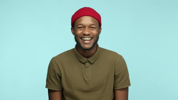 Slow Motion of Carefree Black Man in Red Beanie Having Fun Laughing and Smiling with Braces on Teeth