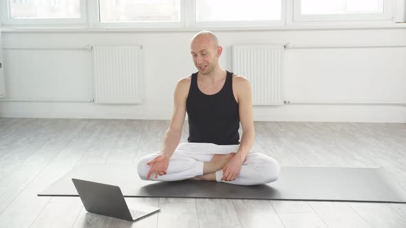 Smiling Male in Sportswear Sit on Mat with Laptop Going to Hold Online Yoga Class