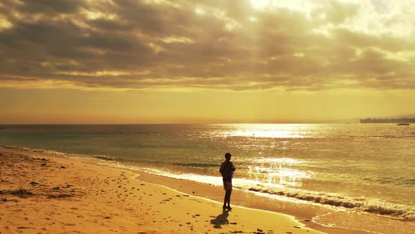 Guy fishing alone on relaxing tourist beach trip by clear water with bright sand background of Bali  alt
