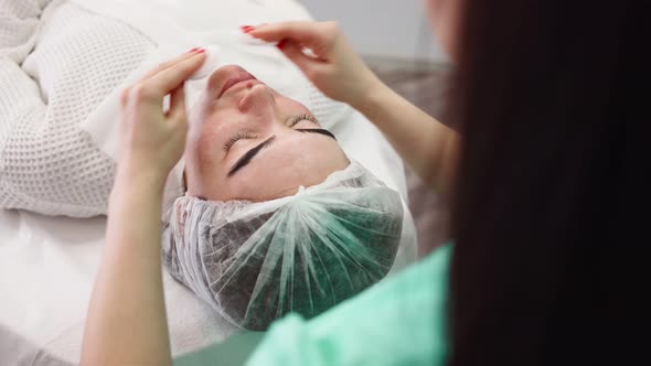Woman Beautician Makes Facial Skin Care Procedure Female Patient in Beauty Salon alt