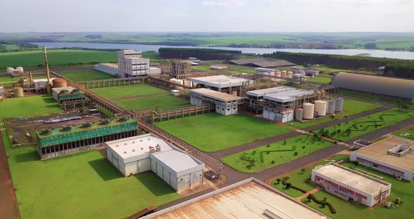 Gigantic installation of an industry in the rural area, in the background we can see a lot of green alt
