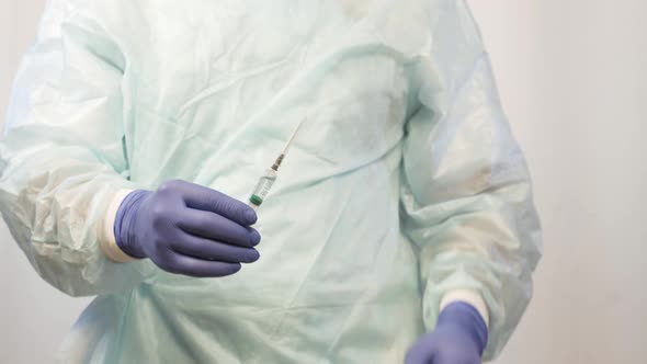 The Doctor Is a Surgeon, Holding a Syringe with the Vaccine. He Is Preparing To Give the Patient an alt