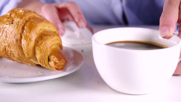 Close-up video of drinks coffee, eating french croissant