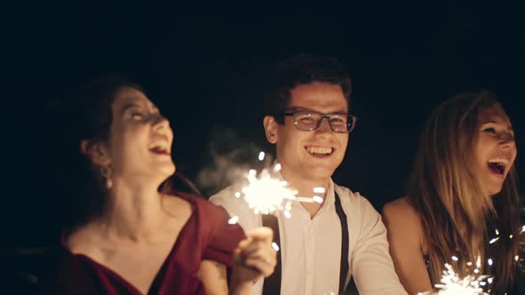 Large Group of Multiracial Friends or Acquaintances Holding and Waving Sparklers alt