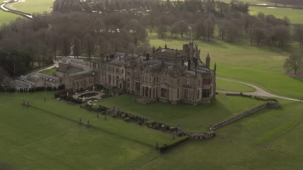 parallax drone shot of castle mansion on sunny day alt