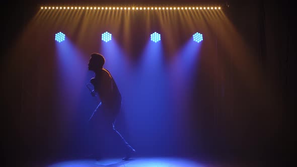 A Black Man Bangs on an African Talking Drum Yuka and Dances To the Beat of the Music Against a alt