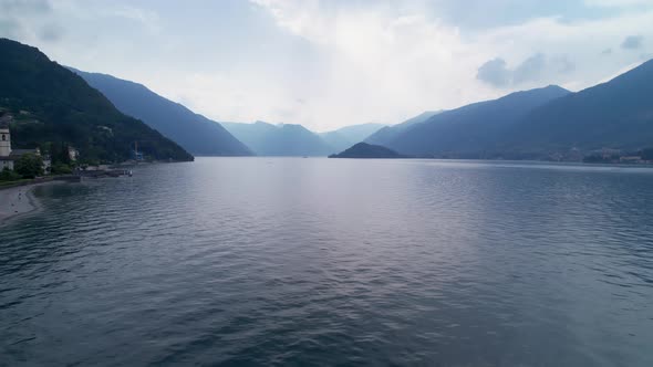 Drone flying low over surface of lake Como in Italy alt