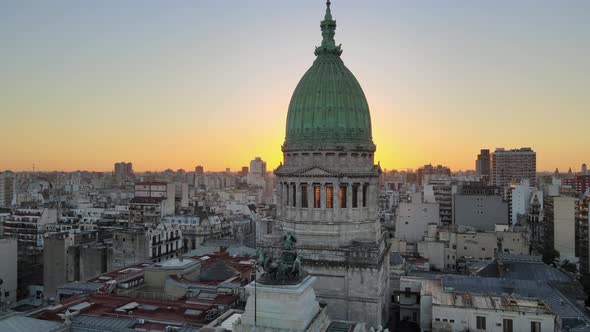 Aerial dolly out of Argentine Congress building with green bronze dome at sunset in Balvanera neighb alt