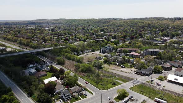 Aerial backwards shot of asphalt highways and bridge with cars in small Canadian village near Lake O alt