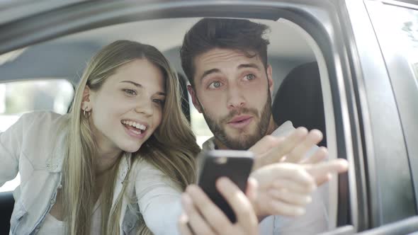 Couple using smartphone in car