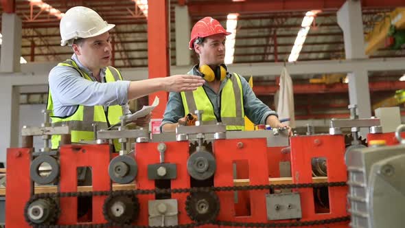 Two young engineers Testing and verifying the operation of the machines alt