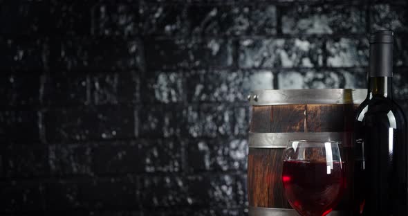 The Wine in the Glass, Bottle and Barrel Slowly Rotates. On Black Background. 