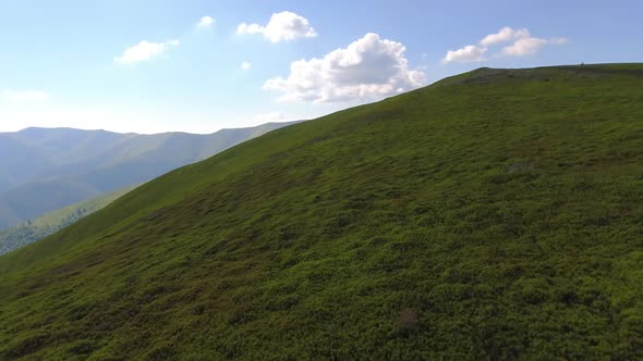 Aerial flight over green hill mountains. FPV Dynamic drone shot alt