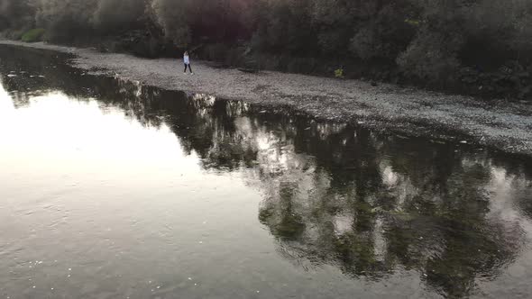 Aerial Drone View of Young Woman Walk Along Mountains River in Summer Morning alt